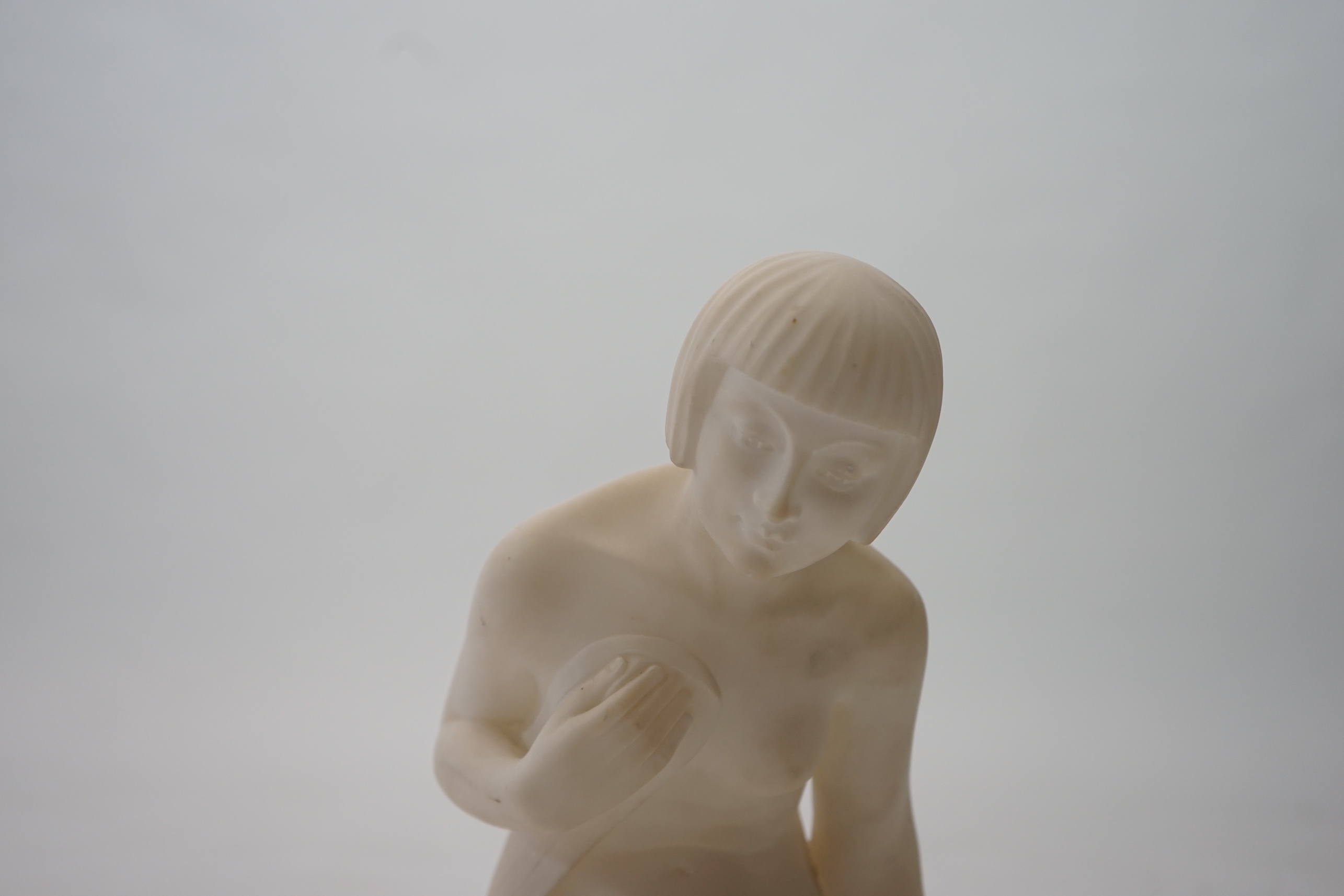 Manner of Gugliemo Pugi (1850-1915). An Italian Art Deco carved marble figure of a crouching bather kneeling and semi-draped